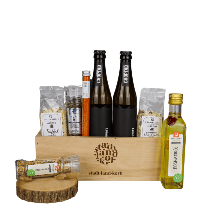 Biergenuss Deluxe Geschenkkorb vor weissem Hintergrund befüllt mit Trüffelrisotto, Pepe Ticino Salz, Chilisalz, Chopfab Bier, Bier-Risotto, Rosmarinöl und Bärgmännesalz