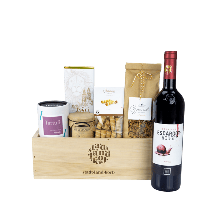 Cheers to Life Geschenkkorb vor weissem Grund befüllt mit Tartufi, Gelee de Prosecco, Taucherli Tsüri Schokolade, Straumann Hüppen, Granola und Escargot Rouge Wein