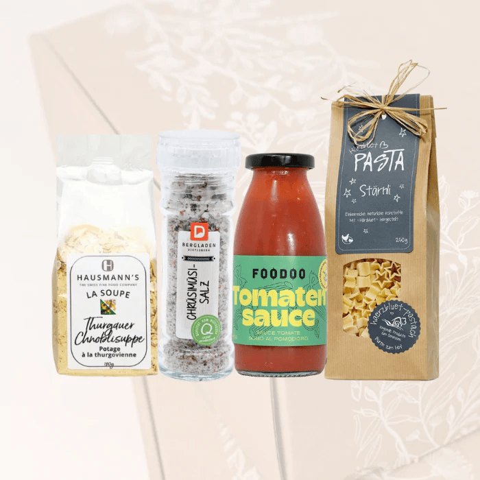 Hausmann's Thurgauer Chnobli Suppe, Chrüsimüsi-Salz, FOODOO Tomatensuppe und Stärnli Pasta vor der transparenten Nature Geschenkbox