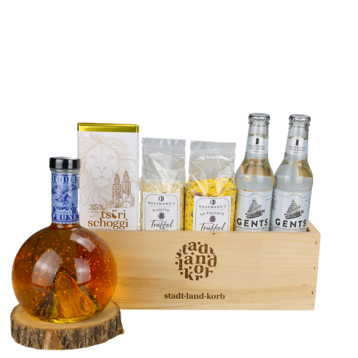 Genussmoment Gold Geschenkkorb vor weissem Hintergrund befüllt mit Gold Prune, Tsüri Schoggi, Trüffel Risotto, Trüffel Polenta und Swiss Tonics