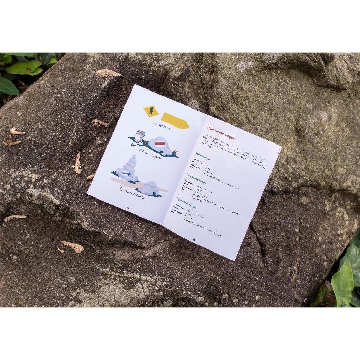 Offenes Wanderjournal auf einem Felsen