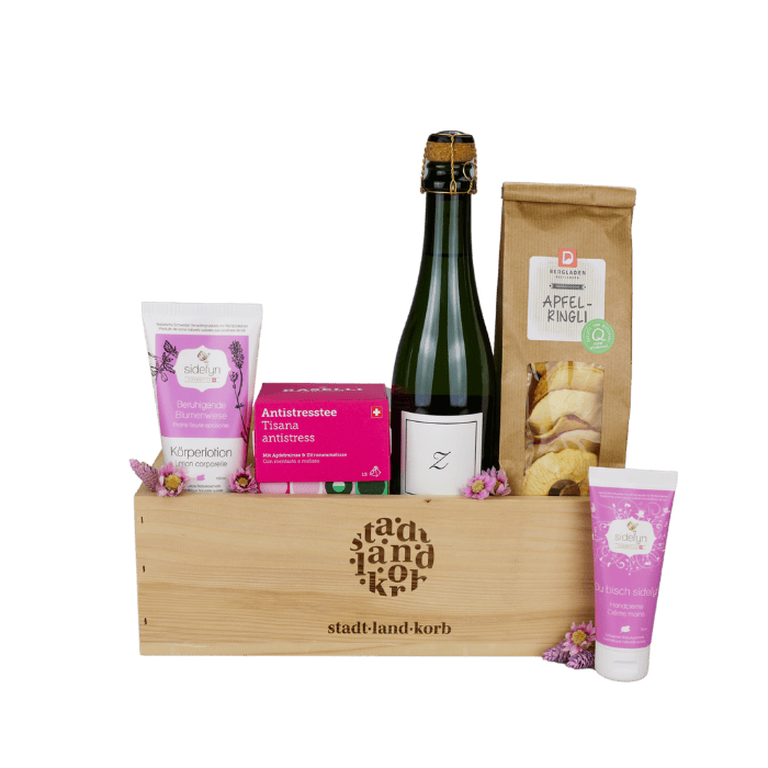 Harmonie & Glanz Geschenkkorb vor weissem Hintergrund befüllt mit Sidefyn Körperlotion, Antistress Tee, Zürischum, Apfelringli und Sidefyn Handcreme
