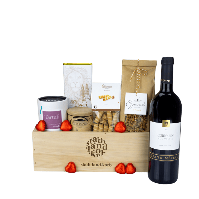 Hochzeitsfreuden Geschenkkorb vor weissem Hintergrund befüllt mit Tartufi, Tsüri Schokolade, Straumann Hüppen, Granola, Cornalin Wein und lindt Schokoladenherzen