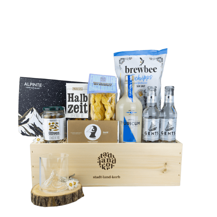 Premium Gin Experience Geschenkkorb vor weissem Hintergrund befüllt mit Alpinte On the Rock Zermatt Gläser, Halbzeit Aperomix, Brewbee Tschipps, Flûtes, Tonics, Turicum Gin und Taucherli Gold Schokolade