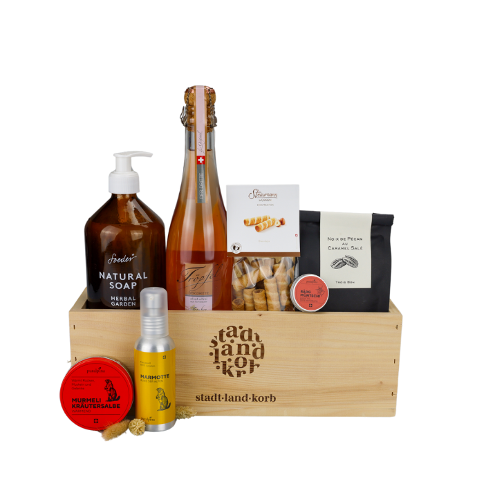 Pure Harmonie Geschenkkorb vor weissem Hintergrund befüllt mit Soeder Natural Soap, Tröpfel der Dritte, Straumann Hüppen, Pekannüsse, Lippgloss, Murmeli Produkte