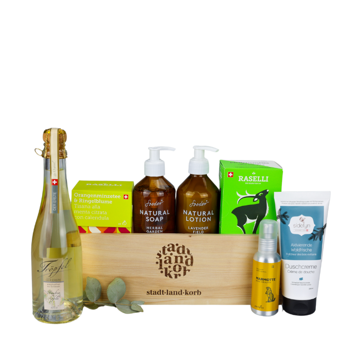 Sinnliche Ruhe Geschenkkorb vor weissem Hintergrund befüllt mit Tröpfel der ERSTE alkoholfreiem Schaumwein, Bio Raselli Tee, Soeder Natural Soap und Natural Lotion, Sidefyn Duschcreme und Marmotte Massageöl