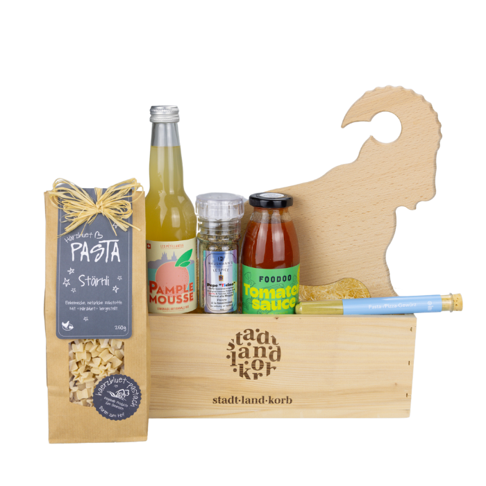 Steinbock Apéro Brett Geschenkkorb vor weissem Hintergrund befüllt mit Stärnli Pasta, Limonade, Pepe Ticino, Foodo Tomatensauce, Apérobrett Steinbock und Pasta/Pizza Gewürz