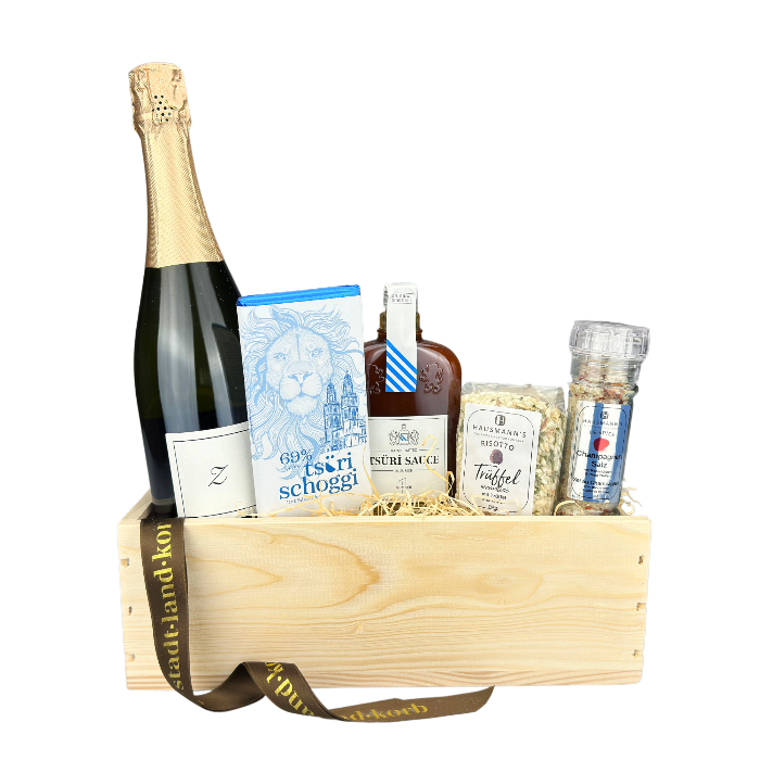 Zürich Geschenkkorb Weekend befüllt mit Zürischum, Tsüri Schoggi, Tsüri Sauce, Trüffel Risotto und Champagner Salz vor weissem Hintergrund.