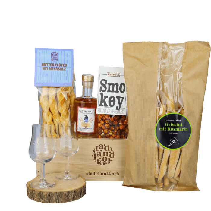 Vatergenuss Geschenkkorb vor weissem Hintergrund befüllt mit Butter Flûtes, Säntis Malt Whisky, Whiskygläser, Smokey Paprika Haselnüsse und Grissini