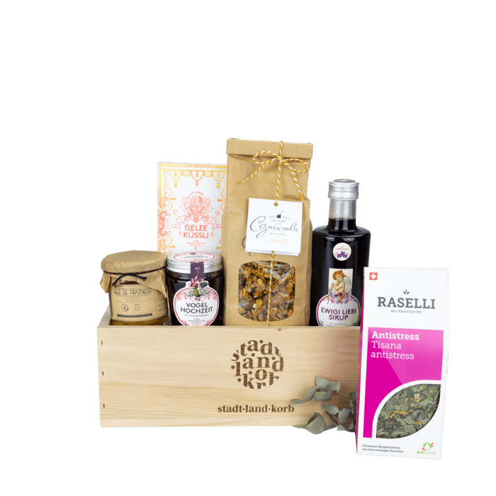 Vogelhochzeit Geschenkkorb vor weissem Hintergrund befüllt mit Vogelhochzeit Konfitüre, Gelee Küssli, Granola, Ewigi Liebi Sirup, Antistresstee und Gelee de Prosecco