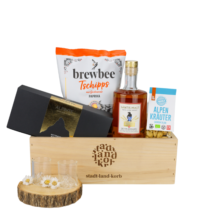 Whisky Moments Geschenkkorb vor weissem Hintergrund befüllt mit Alpinte matterhorn Schnapsgläser, Brewbee Paprika Chips, Säntis Malt Whisky und Alpenkräuter Cashews
