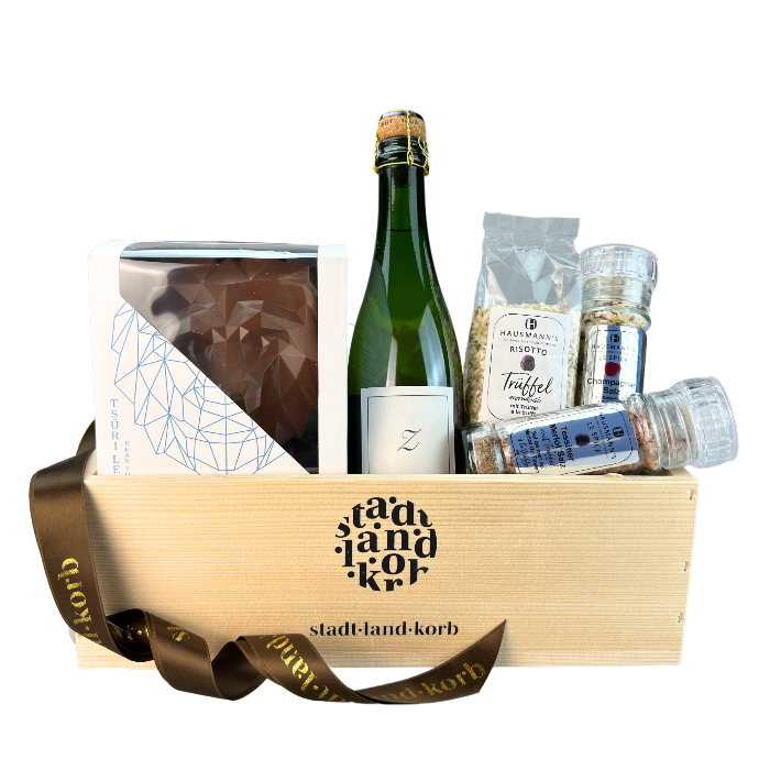 Stadt Land Korb Zürich Geschenkkorb Dinner befüllt mit Tsüri Leu, Zsürischum, Trüffel Risotto, Tessiner Merlotsalz mit Trüffel und Champagner Salz vor weissem Hintergrund.