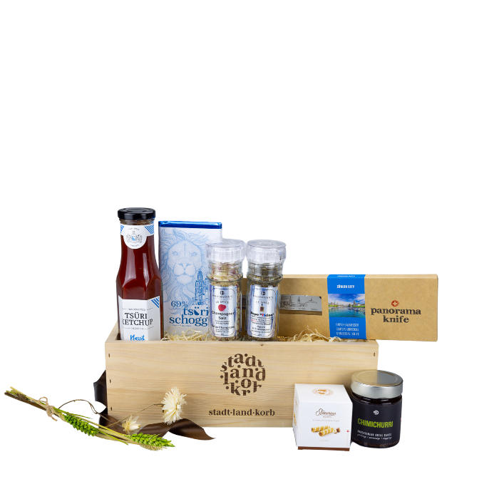 Stadt Land korb Zürich Geschenkkorb Messerscharf befüllt mit Tsüri Ketchup, Tsüri Schoggi, Champagner Salz, Pepe Ticino Pfeffer, Panoramaknife, Straumann Hüppen und Chimichurri Sauce vor weissem Hintergrund.