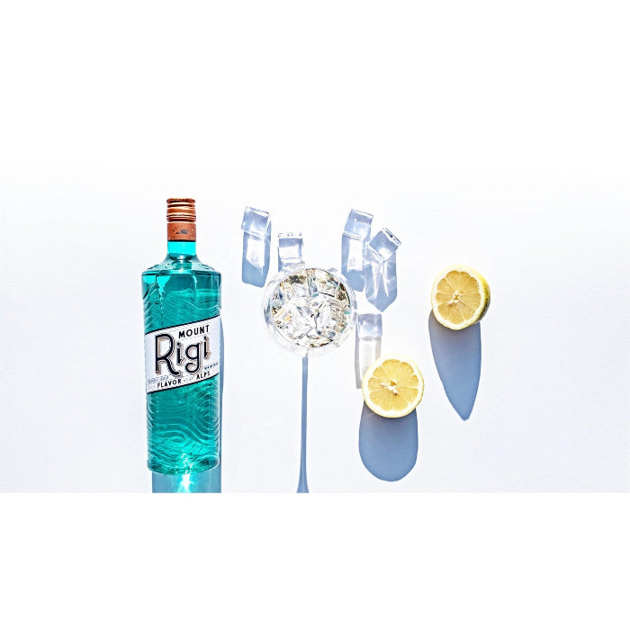 Mount Rigi Likör -Moodbild- Likör, Glas, Zitronen und Eiswürfel vor weissem Hintergrund