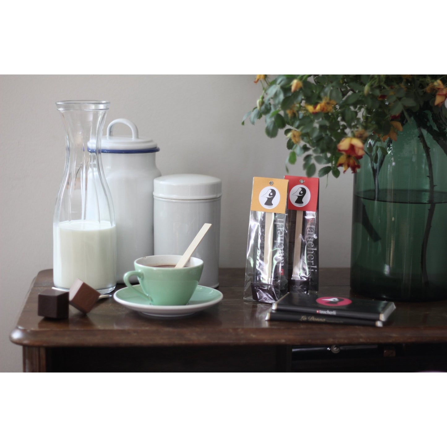Taucherli für Heissi Schoggi Moodbild mit Milch, Tassen und Vase auf einem Holztisch