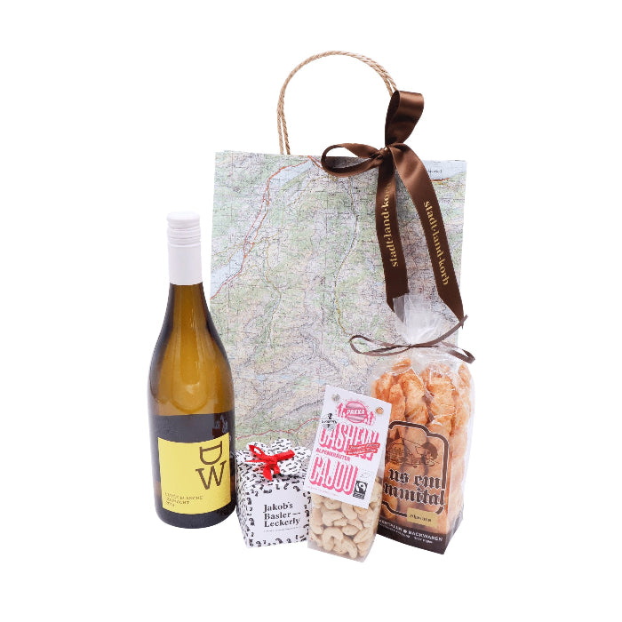 Zum Wohl Mapbag: DW Weisswein, Jakob's Basler Leckerly, Pakka Cashew Nüsse und Flûtes aus dem Emmental vor einem Mapbag vor weissem Hintergrund.