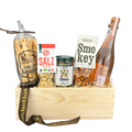 Apero Classico Holz Geschenkkorb befüllt mit Flûtes aus dem Emmental, Pakka Cashew Nüsse mit Salz, Mahler & Co Oliven, Mahler & Co Smokey Haselnüsse und alkoholfreiem Schaumwein Tröpfel DER DRITTE. Vor weissem Hintergrund.