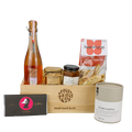 Genuss und Geborgenheit Geschenkkorb vor weissem Hintergrund befüllt mit Töpfel der Dritte, Gelee de prosecco, Caramel Beurre salé, Cantucci, Edelweiss Tee und Taucherli Schokolade