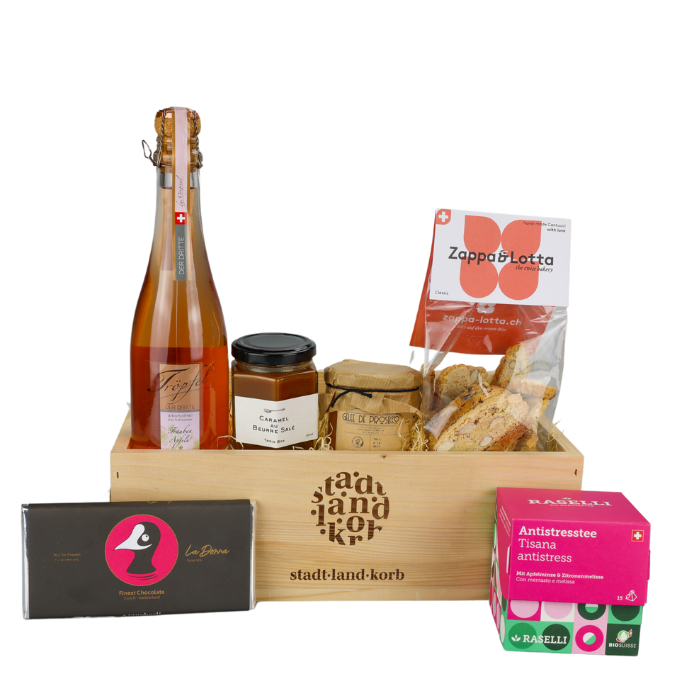 Genusszeit für Mama Geschenkkorb vor weissem Hintergrund befüllt mit Tröpfel der Dritte, Beurre Salé, Gelee de Prosecco, Cantucchi, Antistresstee und Taucherli Schokolade