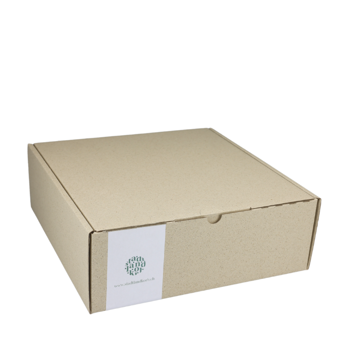 Geschenkkarton aus Graspapier vor weissem Hintergrund