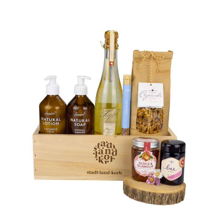 Sinfonie der Sinne Alkoholfrei Geschenkkorb vor weissem Hintergrund befüllt mit Soeder Natural Lotion & Natural Soap, Tröpfel der Erste, Blütenzauber, Granola, Konfitüre und Honig