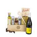 Stadt Land Korb Weisswein Dinner Geschenkkorb befüllt mit Rosmarinöl, Champagner Salz, Tomatenpesto, Pepe Ticino Pfeffer. Bonetti Hörnli, Kochlöffel Steinbock und DW Weisswein vor weissem Hintergrund. 